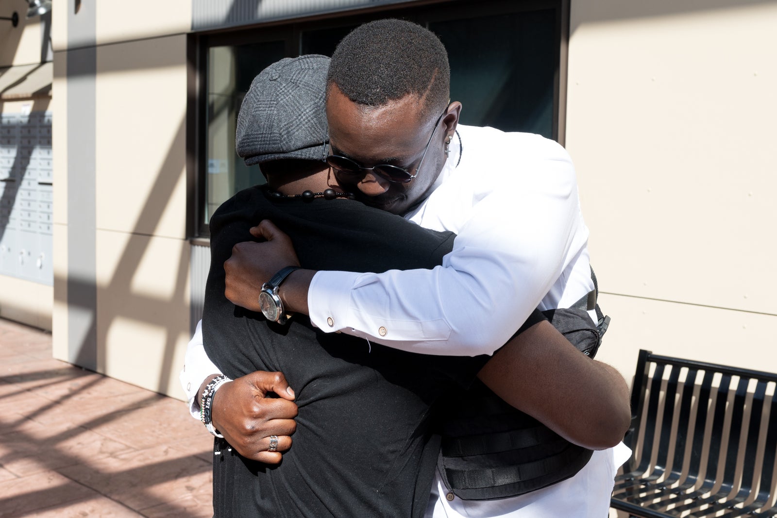Dois homens negros se abraçando.